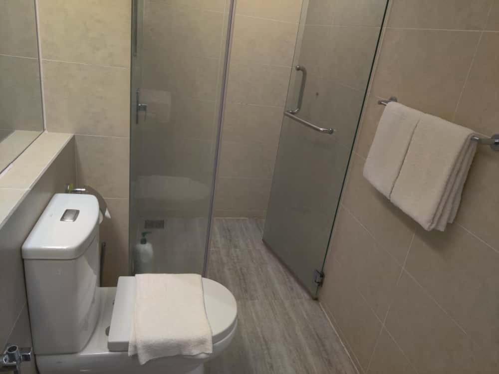 Un baño con inodoro y ducha con toallas. en Windmill Upon Hills Genting Highland by El Naura, en Genting Highlands