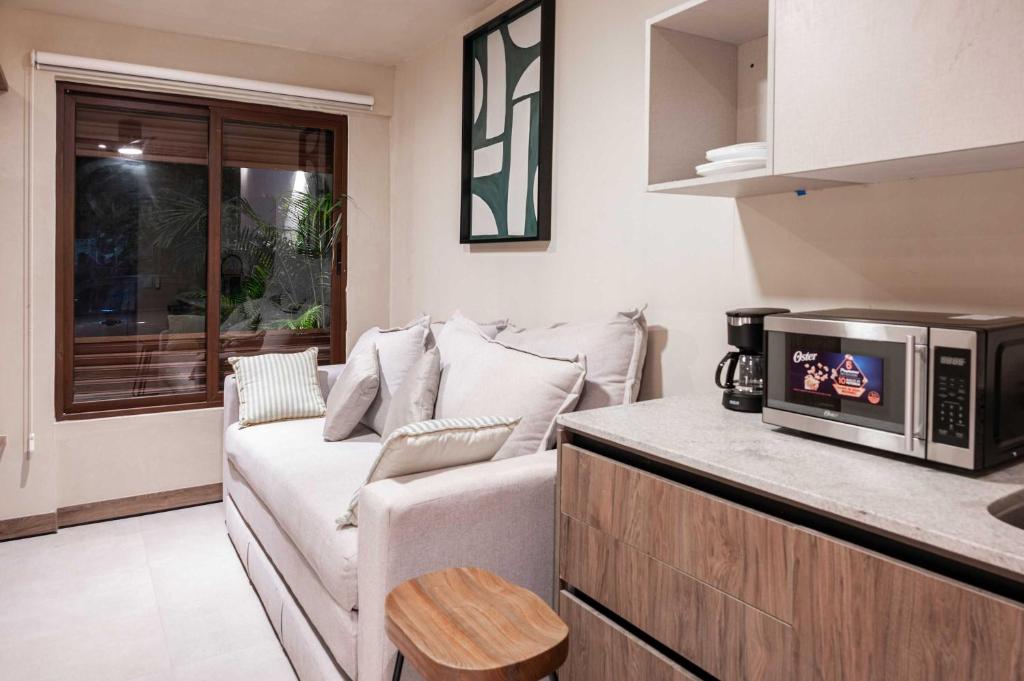 a living room with a couch and a microwave at Stylish Double Studio with Equipped Kitchen and Wi-Fi in Bucerías