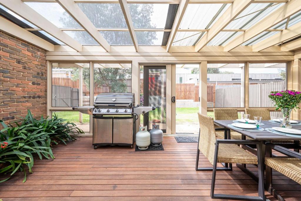 Un patio cubierto con parrilla y mesa. en Queens Beach Retreat - Beachside Coastal Escape, en Sorrento