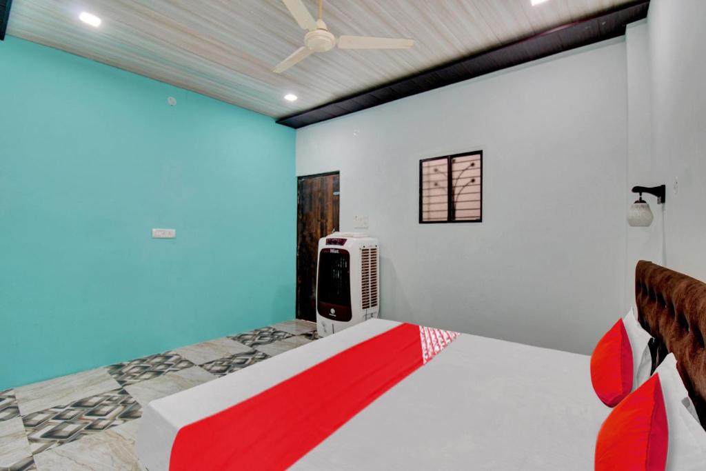 une chambre avec un lit avec une télévision dessus dans l'établissement Hotel O The Village Resort, à Itwāri