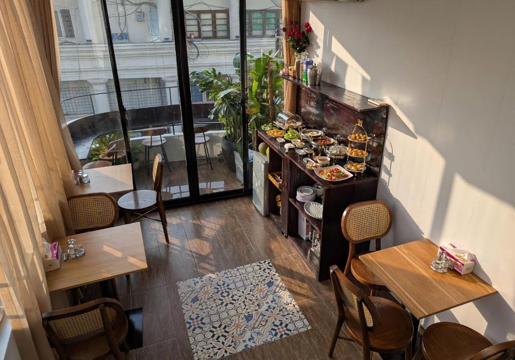 a restaurant with tables and chairs and a buffet of food at Maison Maravelle Hotel - Boutique Stay in Hanoi Old Quarter in Hanoi