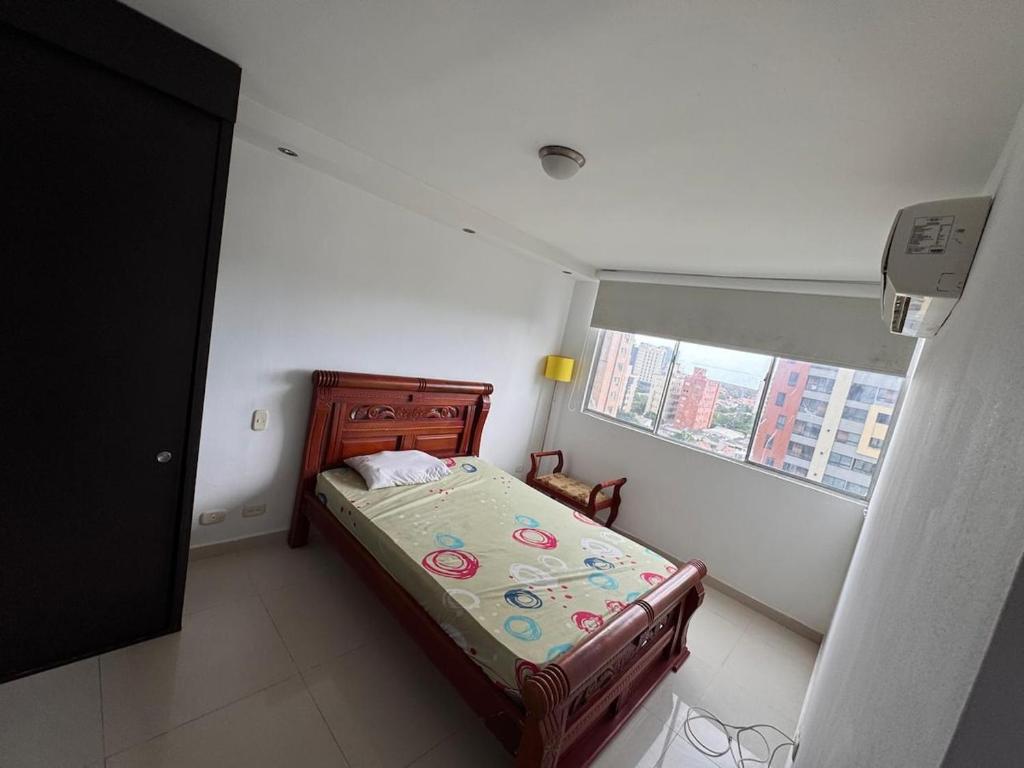 a small bedroom with a bed and a window at Apartamento amoblado en el norte de barranquilla in Barranquilla