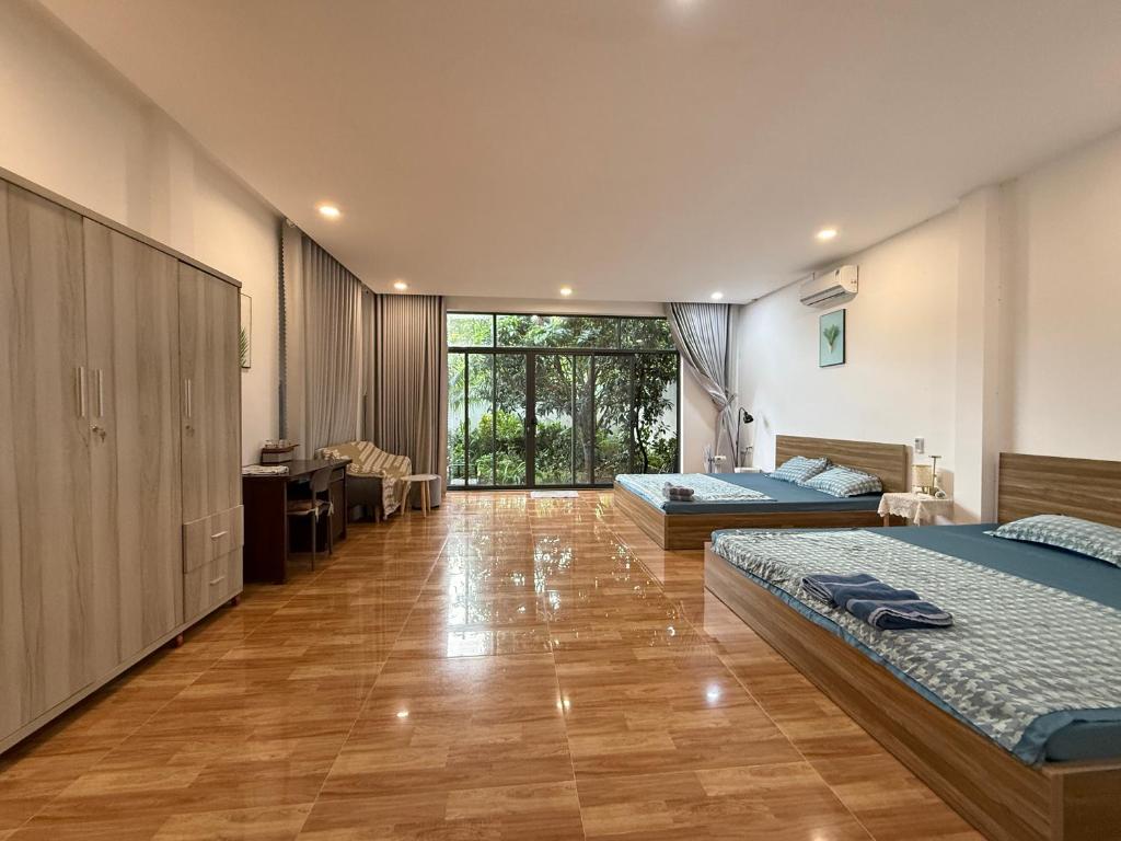 a large room with two beds and a desk at homestay halona in Phu Quoc