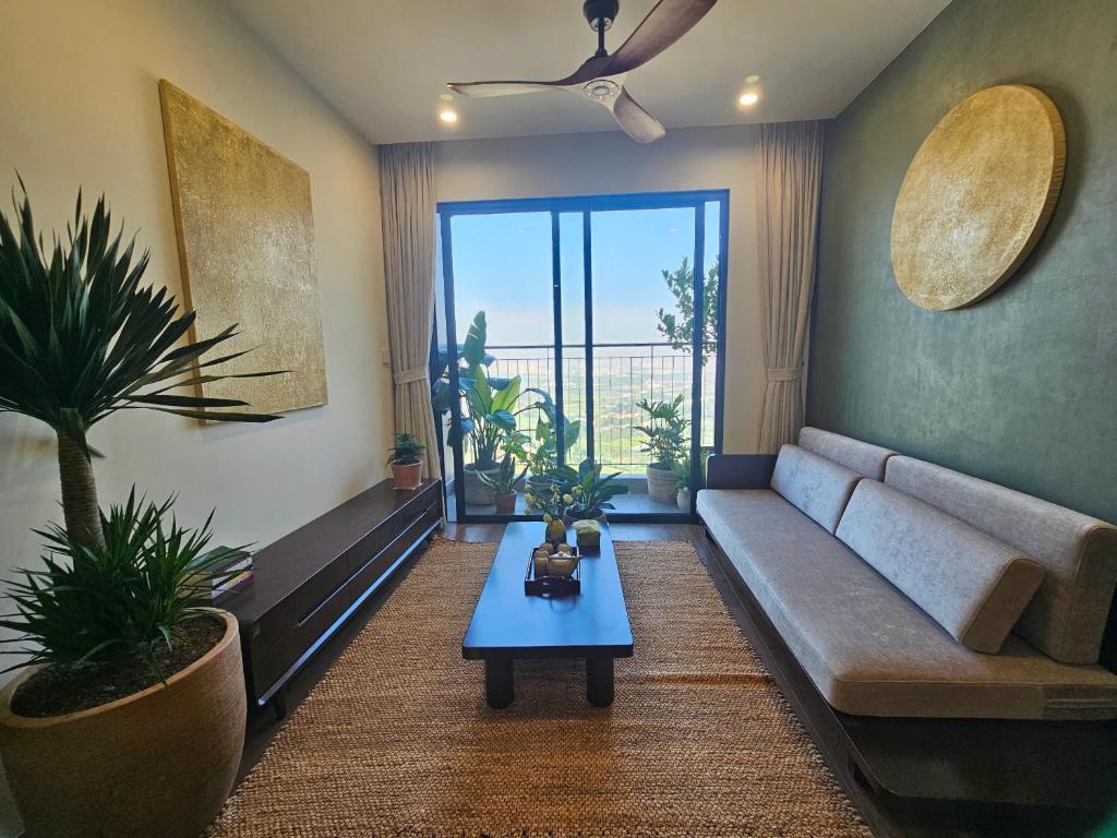 una sala de estar con un sofá y una mesa en The Inner Home 2BR Healing Stay at Vinhomes Ocean Park Hanoi, en Gia Lâm Pho