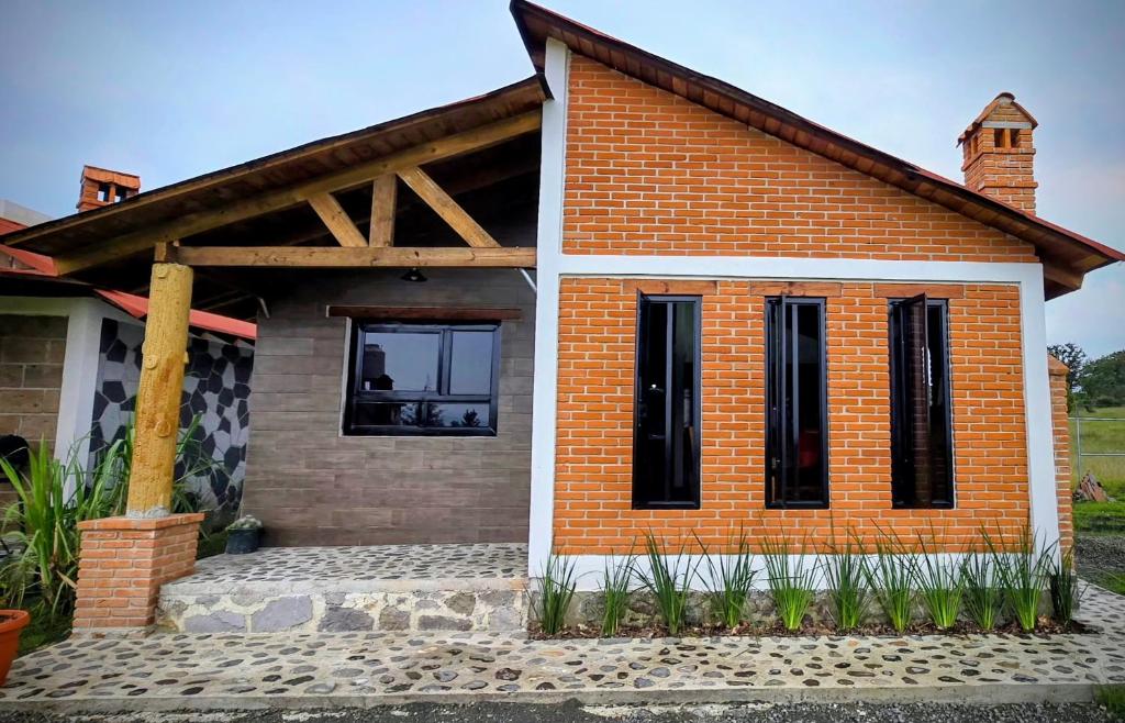 a small brick house with a roof at Cabañas el Corral del Rayo Huasca in Huasca de Ocampo