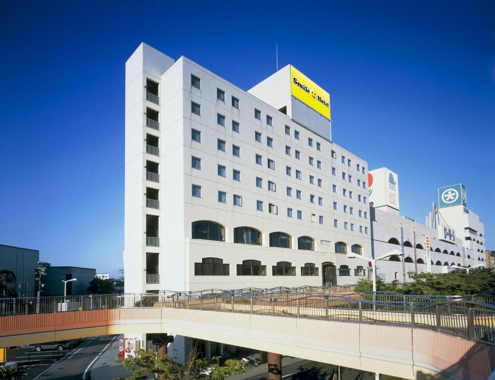a white building with a bridge in front of it at Smile Hotel Shimonoseki in Shimonoseki