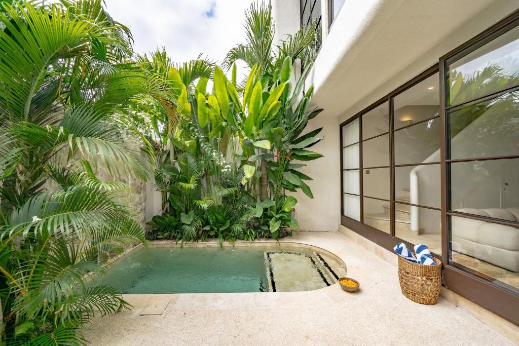 an indoor pool in the middle of a house with palm trees at Villa Ceylon 4 Uluwatu in Uluwatu
