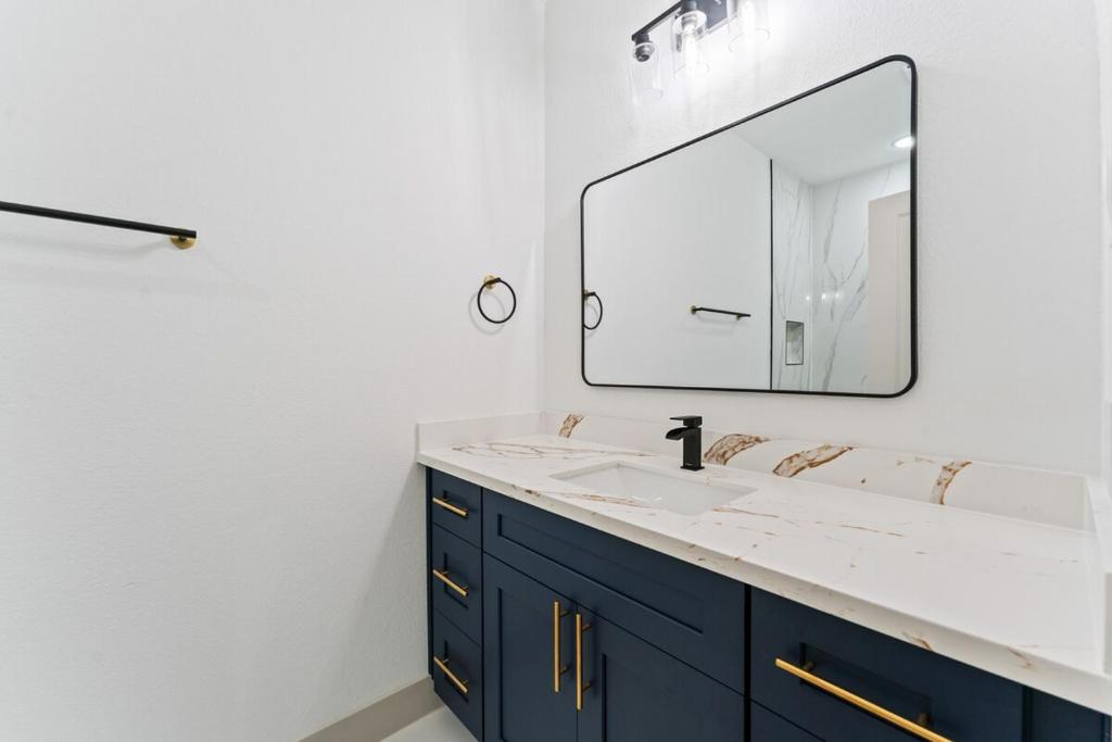 a bathroom with a sink and a mirror at Little Nyssa Home away from Home in Houston