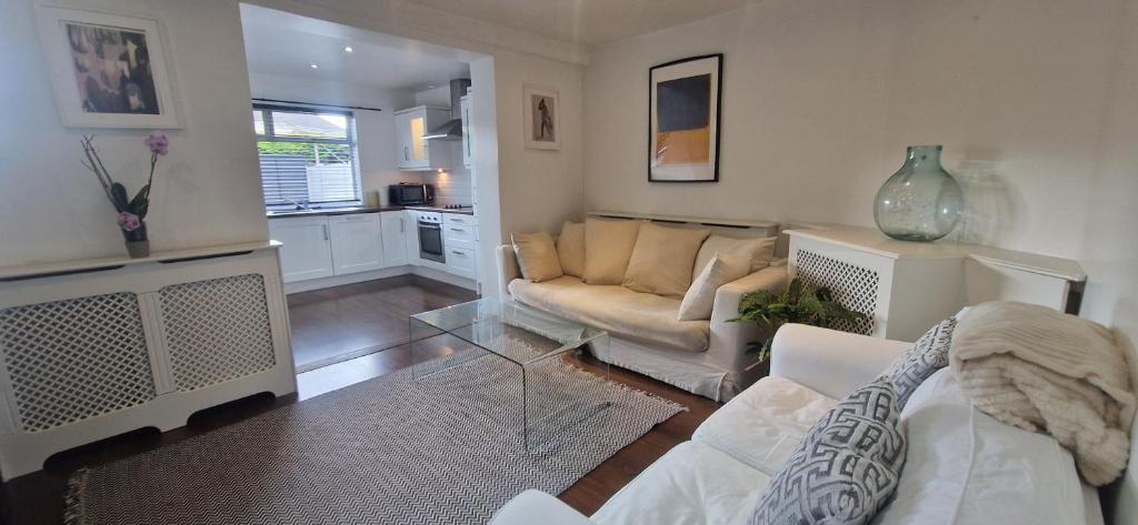 una sala de estar con un sofá y una mesa en Cozy 2BDR Home Near Luas 5km to City Centre, en Dolphinʼs Barn