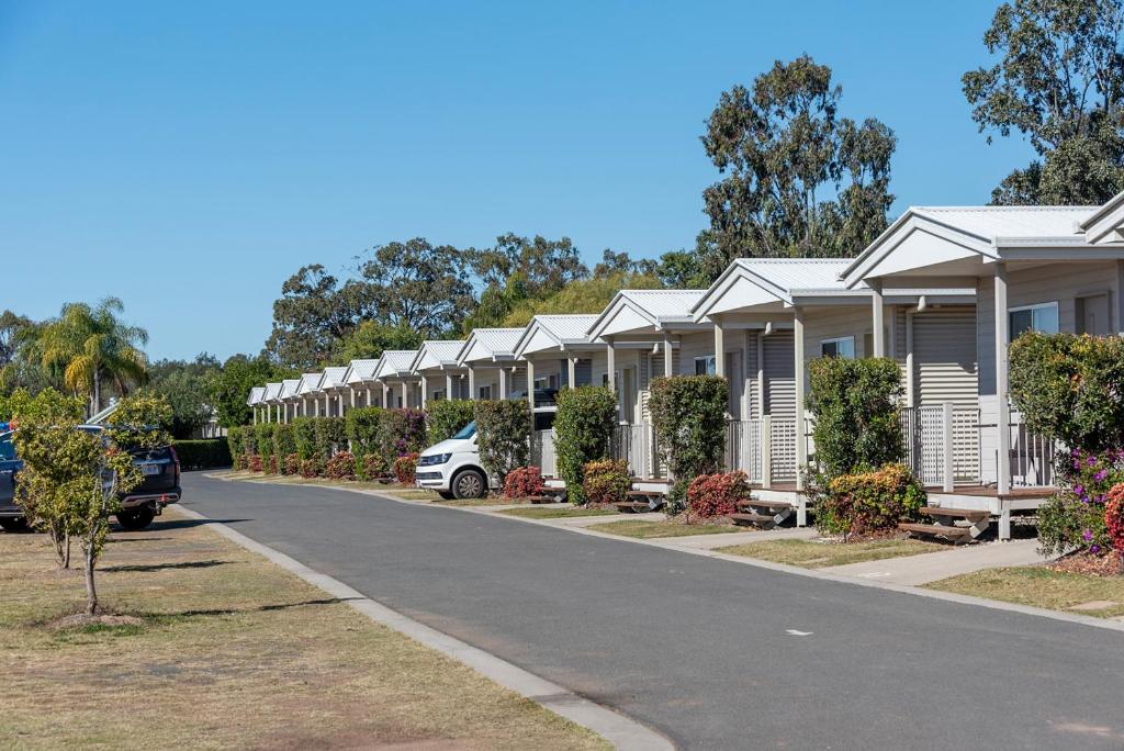 a row of houses with cars parked on the street at Chinchilla Tourist Park in Chinchilla