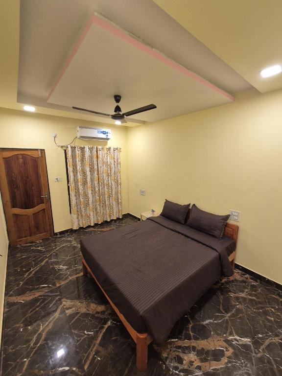 a bedroom with a bed and a ceiling fan at Svayambhu Stay in Bhogwe