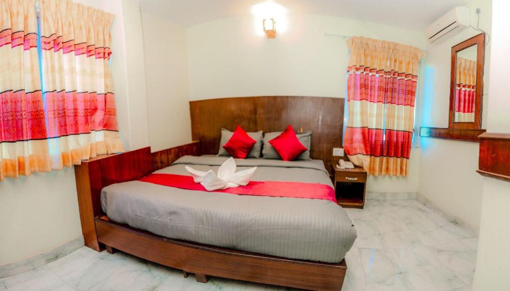 Un dormitorio con una cama grande con almohadas rojas. en Hotel Lekali Pvt Ltd, en Pokhara