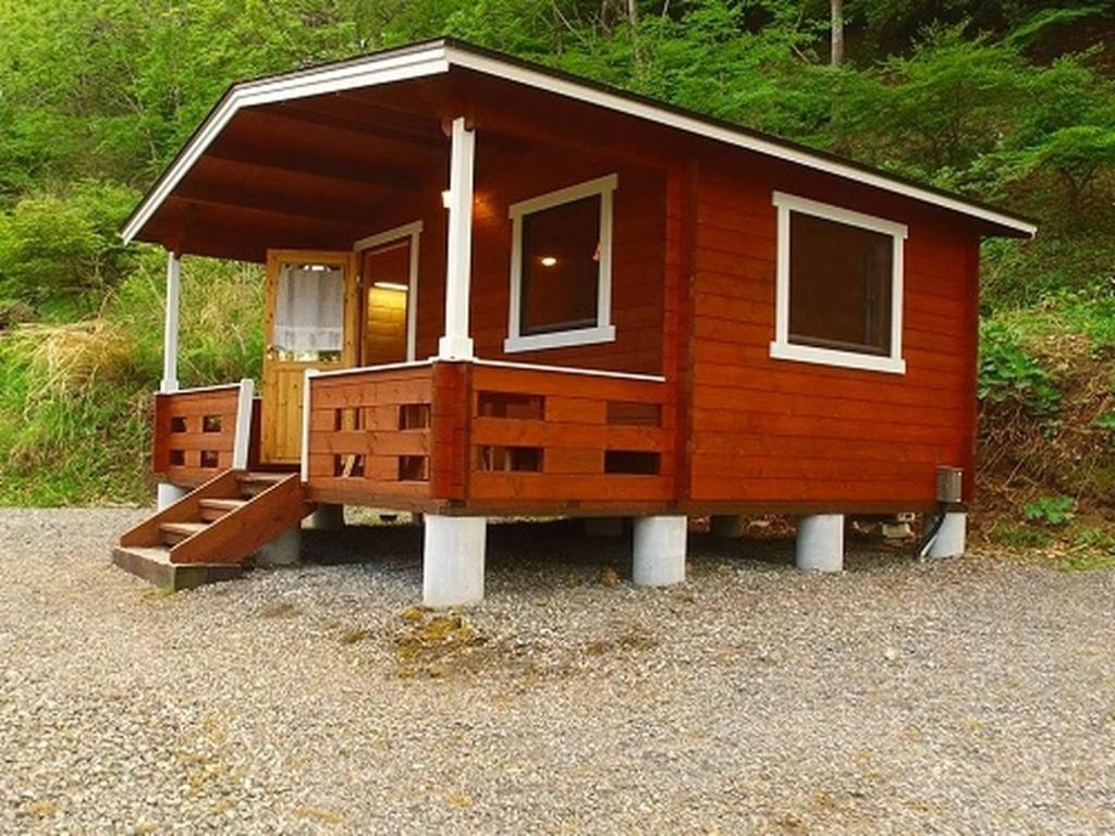 Cette petite cabine dispose d'une terrasse couverte et d'un escalier. dans l'établissement Foresters Village Kobitto Southern Alps Camp Field - Vacation STAY 78096v, à Shirasu