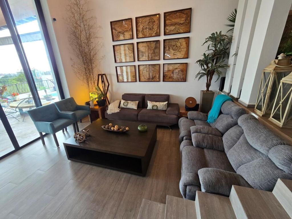 a living room with a couch and a table at The White House has everything in Chantepec