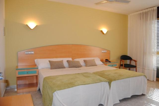 a bedroom with a large bed with a wooden headboard at Hotel Riveiro in Sanxenxo