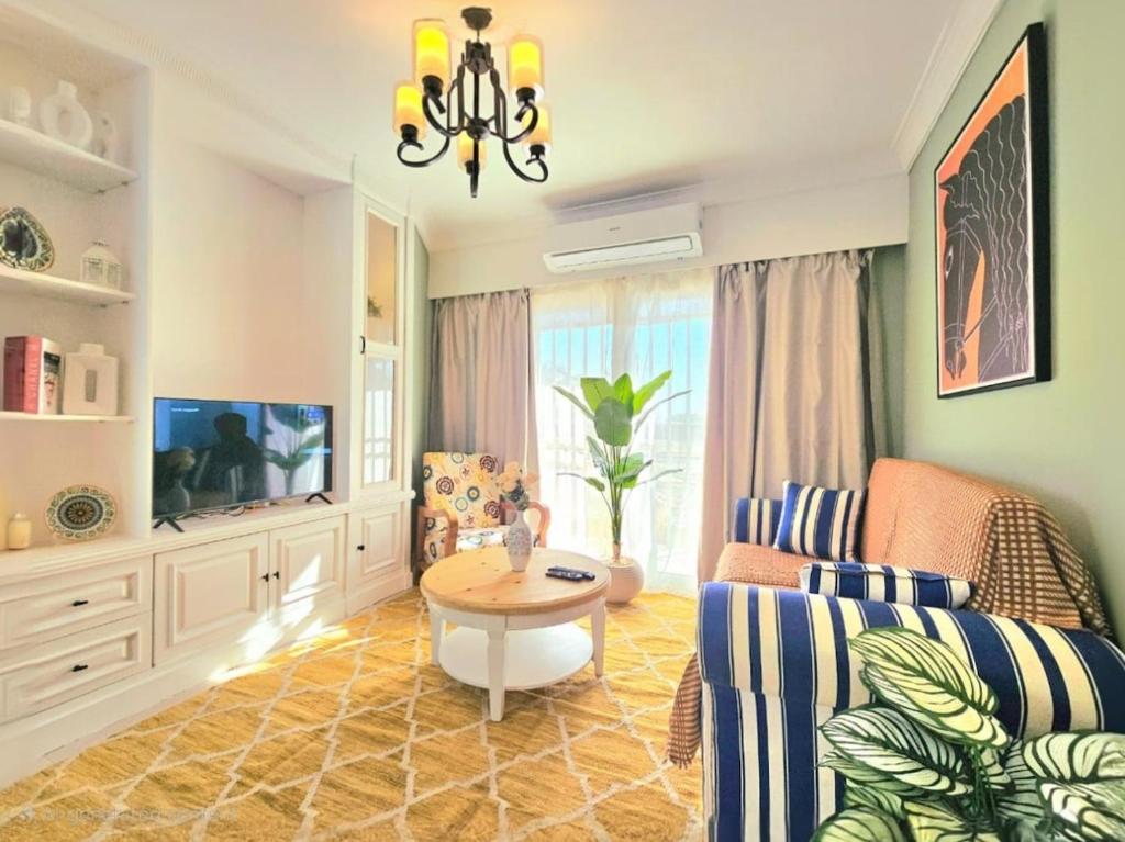 a living room with a couch and a table at Stunning and warm near East Hub in Madinaty in Madinaty
