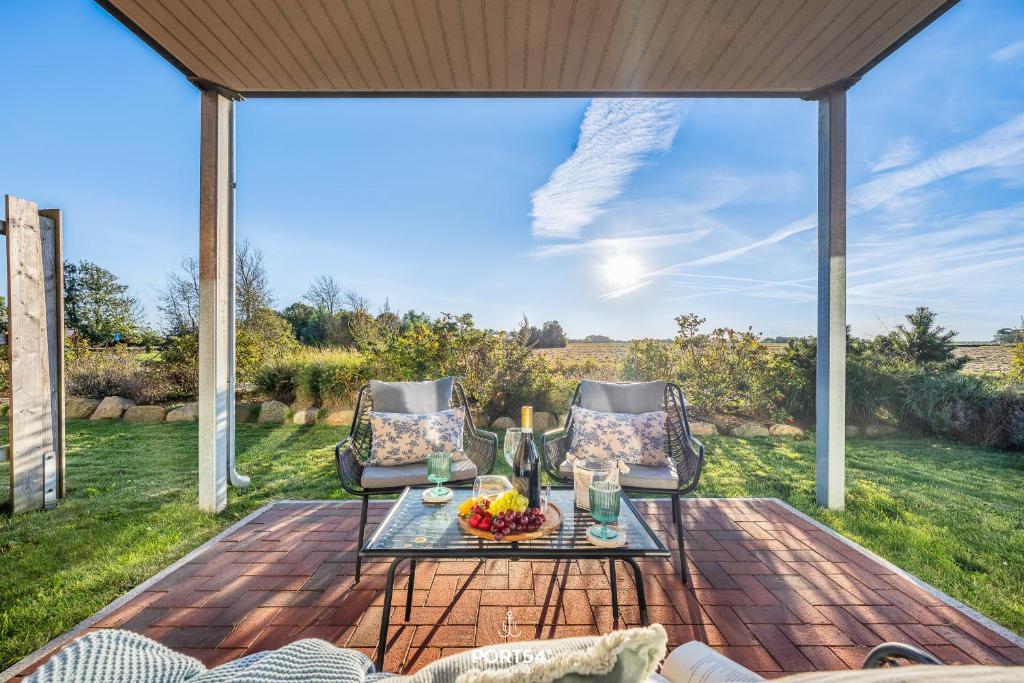 eine Terrasse mit zwei Stühlen und einem Tisch mit einer Obstschale in der Unterkunft Meerverliebt in Büsum