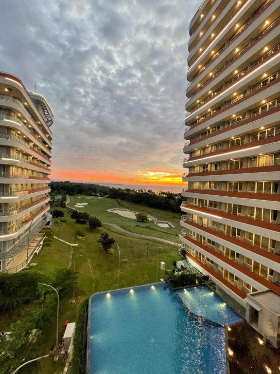 - une vue sur un grand bâtiment avec une piscine dans l'établissement Deluxe Room Sea View Pool Golf Nuvasa Bay Kalani Tower, à Pulau Nongsa