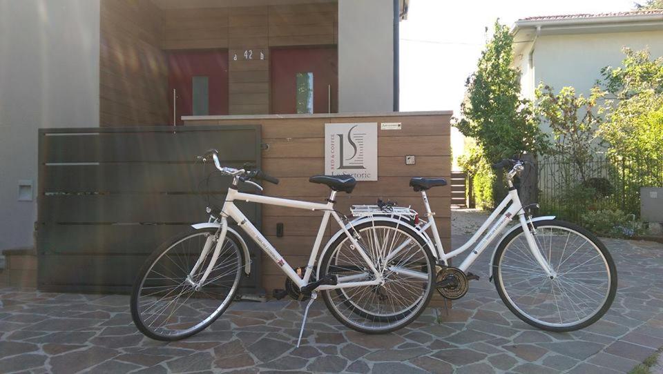 Una bicicleta blanca estacionada al lado de un edificio en Le Sartorie, en Pozzuolo del Friuli