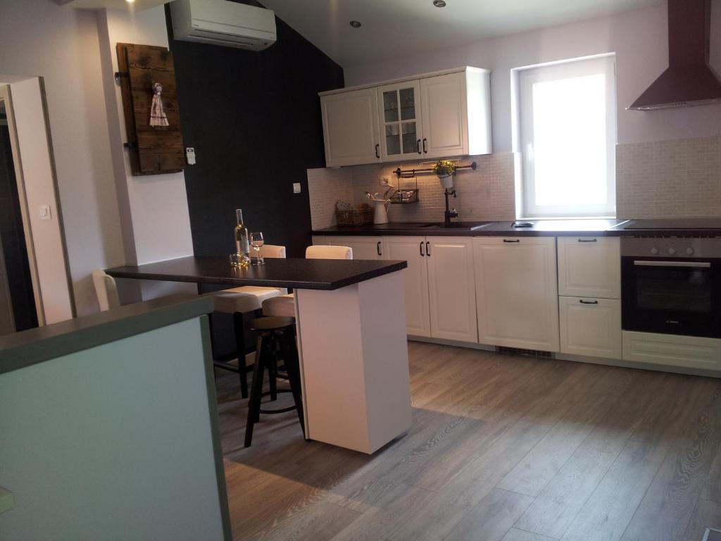 a kitchen with white cabinets and a black counter top at Apartment Diminic Melin in Cres