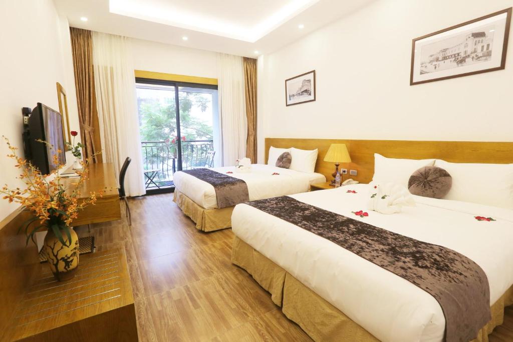 a hotel room with two beds and a television at Family Hanoi Hotel in Hanoi