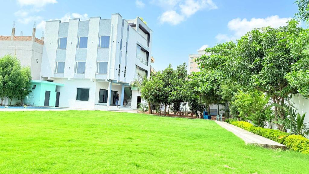 a large grassy yard in front of a building at Hotel O ISKCON Temple Bhopal Formerly Hotel Yaswant in Islāmnagar