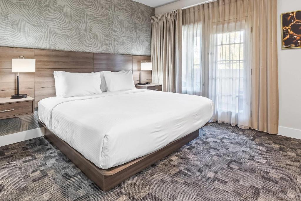 戴维斯University Park Inn & Suites, an Ascend Collection Hotel的一间卧室，配有一张大床和一扇窗户。