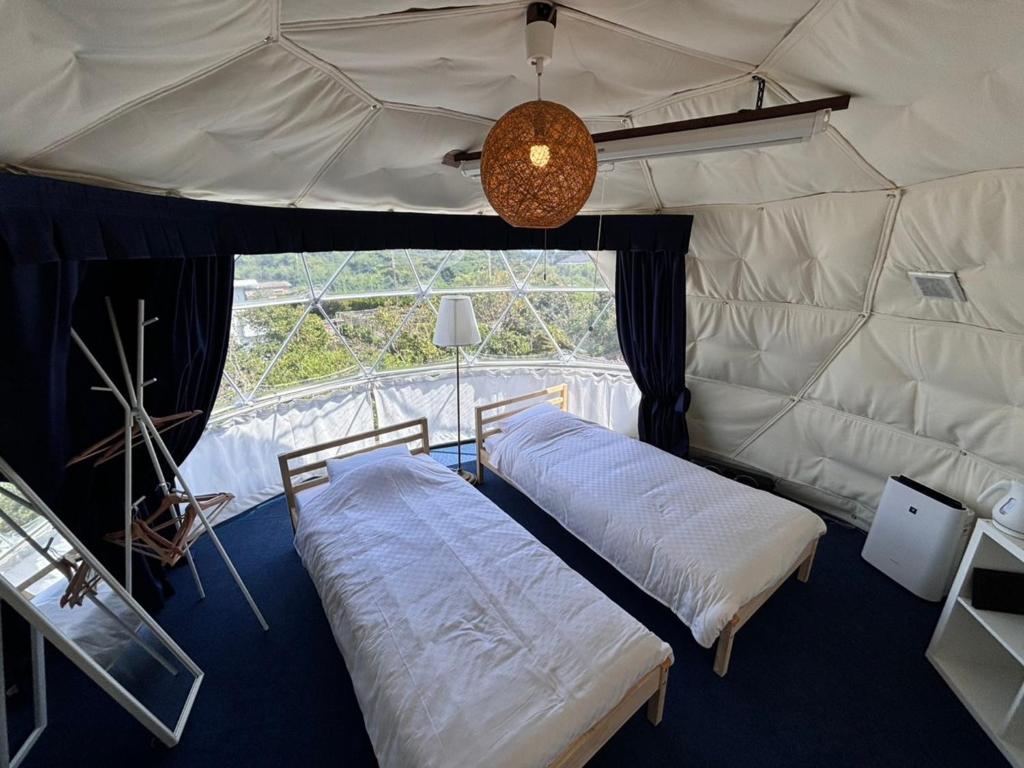 two beds in a room with a large window at oceanhouse iseshima - Vacation STAY 67873v in Kō