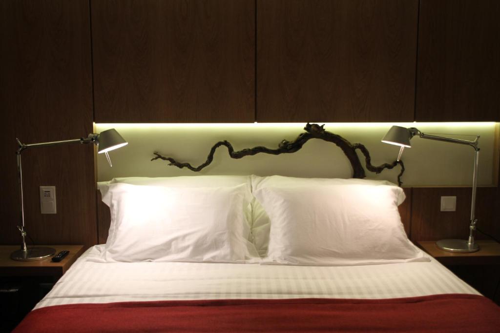 a bed with two white pillows and two lamps at Quinta Vale da Roca in Sintra
