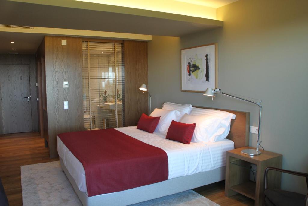 a bedroom with a large bed with red and white pillows at Quinta Vale da Roca in Sintra