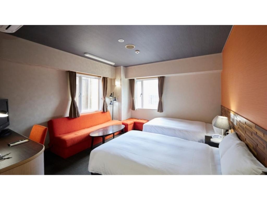 a hotel room with two beds and a couch at Smile Hotel Miyakojima - Vacation STAY 93495v in Miyako Island