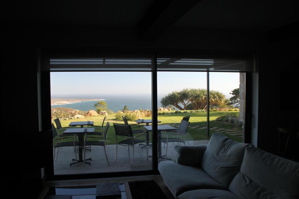 a living room with a couch and a view of the ocean at Quinta Vale da Roca in Sintra