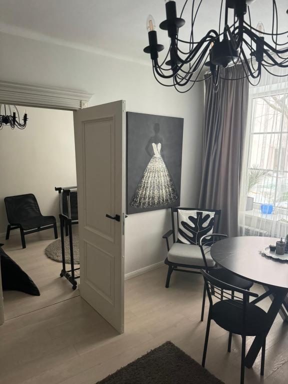 a living room with a table and chairs and a chandelier at Old town apartment in Vilnius