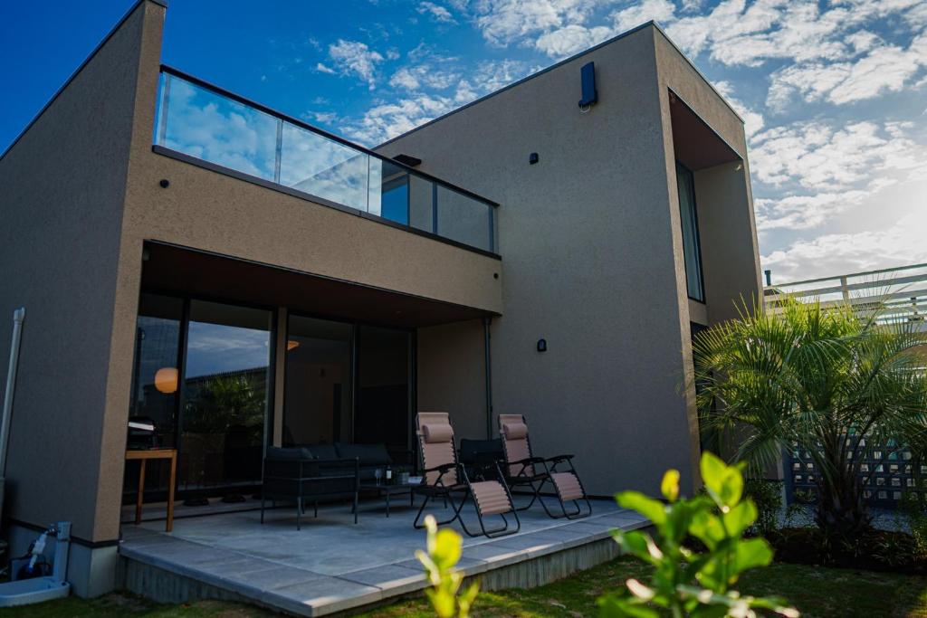 a house with glass doors and chairs on a patio at Star-Seven Itoshima - Vacation STAY 20184 in Keya