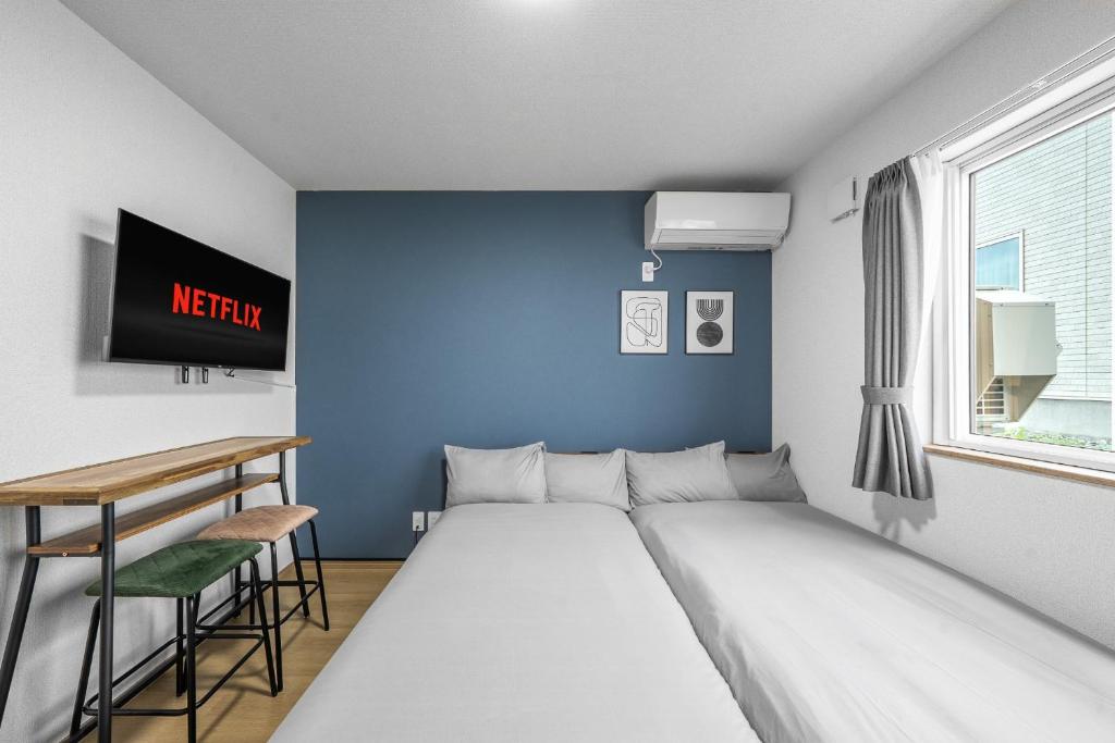 a bed in a room with a blue wall at Charmant House III - Vacation STAY 20173 in Minamifurano