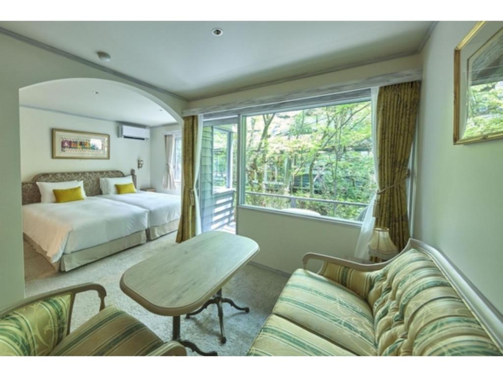 a bedroom with a bed and a table and a couch at Auberge de Primavera - Vacation STAY 40780v in Shin-karuisawa