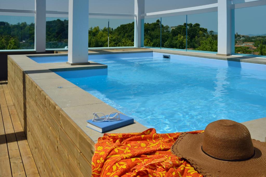 a hat and a pair of glasses on a blanket next to a swimming pool at Embassy Hotel & Spa in Cattolica