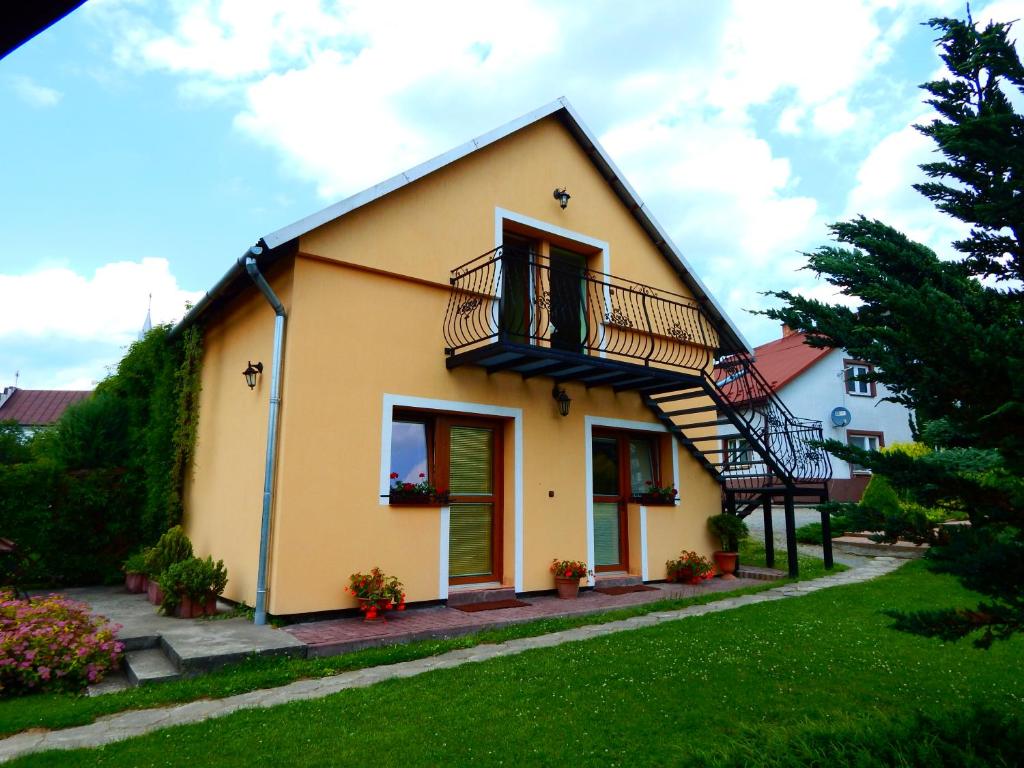 索利納的住宿－Pokoje nad Potokiem，黄色的房子,上面有楼梯