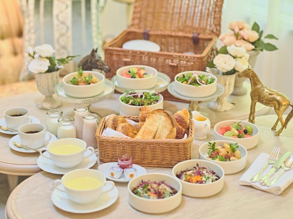 a table topped with dishes of food and a basket of bread at Auberge de Primavera - Vacation STAY 40836v in Shin-karuisawa