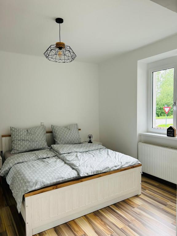 a bed in a white bedroom with a window at Guesthouse Tulln in Tulln