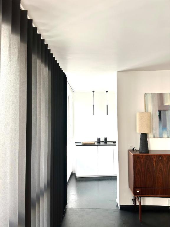 een hal met witte muren en een tafel met een lamp bij design apartment in Parijs