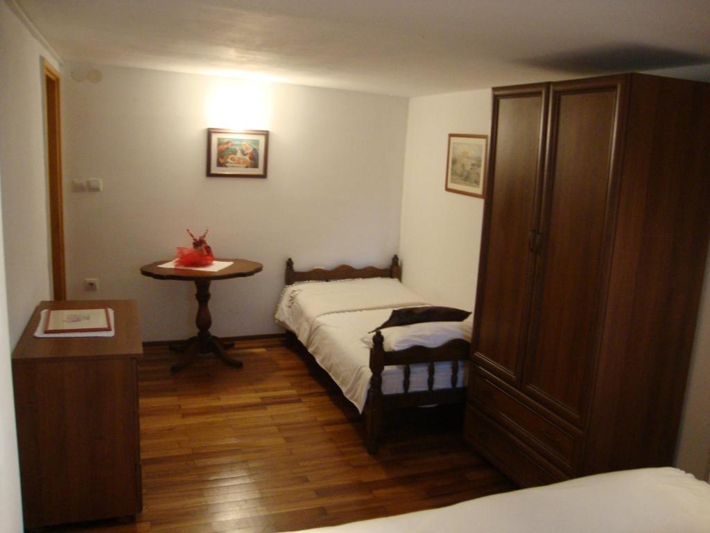 ein kleines Schlafzimmer mit einem Bett und einem Tisch in der Unterkunft Apartment Kaucic in Banjole