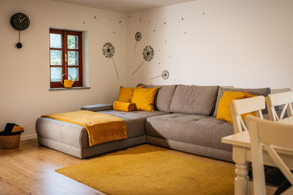 un soggiorno con divano grigio e cuscini gialli di Bee House a Rogaška Slatina