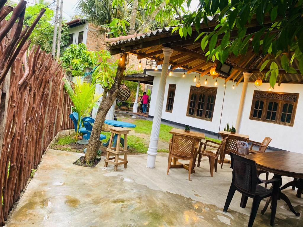 Un patio al aire libre con mesa y sillas. en Sandy Coconut Guest, en Mirissa