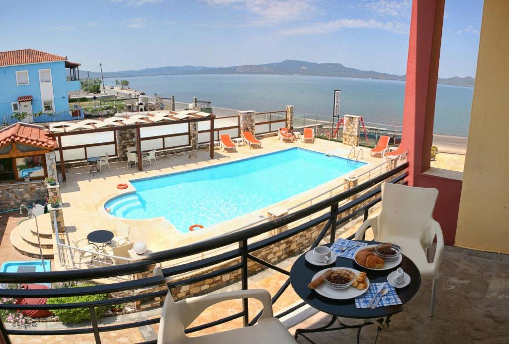 balkon z basenem i stołem z jedzeniem w obiekcie Gera Bay Studios And Apartments w mieście Apidias Lakos