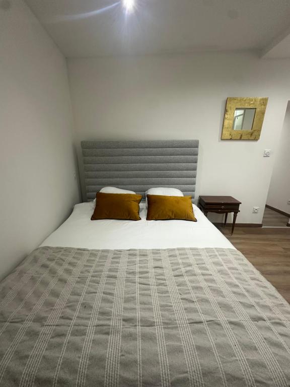 a bedroom with a large bed with two pillows at Normandy suites - APPARTEMENT RENOVÉ À 45 MIN DU MANS in Igé