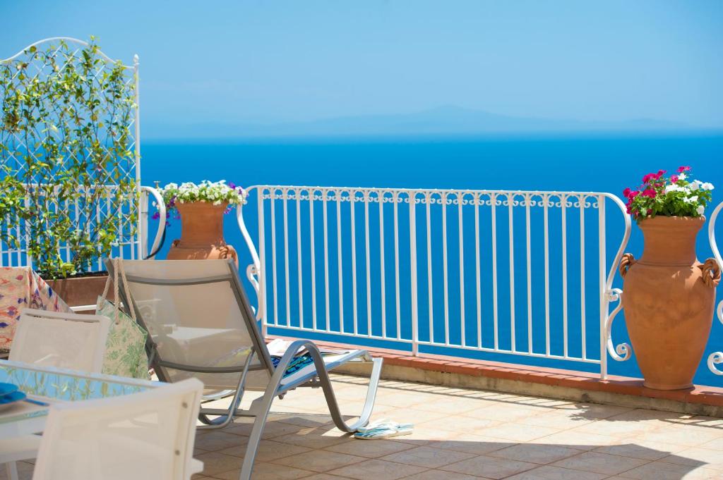 une clôture bleue, une chaise et quelques plantes dans l'établissement Le Anfore 2 - Amalfi Coast, à Conca dei Marini