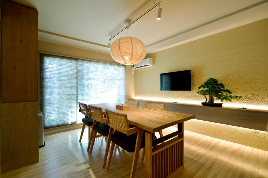 a dining room with a wooden table and chairs at Grand Success Kotoni V in Kotoni