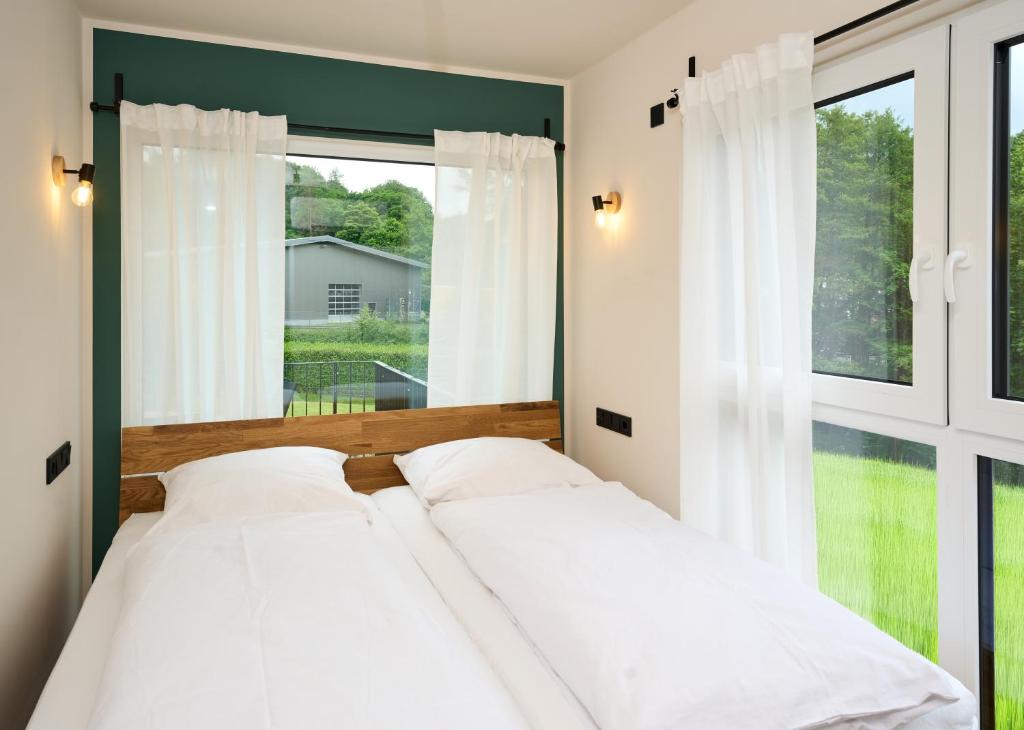 a bedroom with a bed and a large window at Luxuscontainer am Nürburgring #4 in Adenau