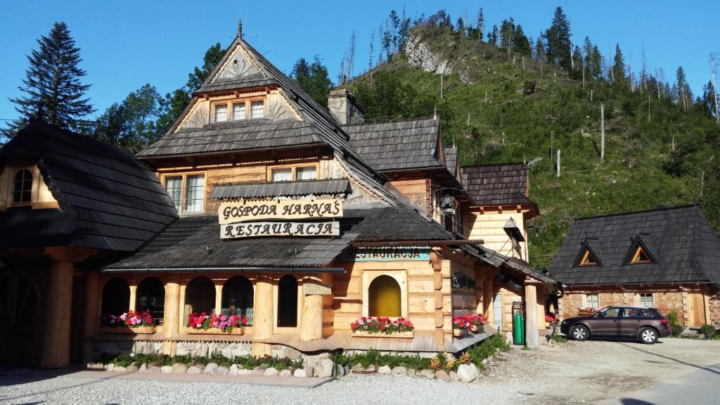 a large wooden building in front of a mountain at Gospoda Harnaś in Kościelisko